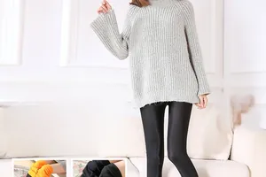 Detail view of glossy black leggings featuring warm orange thermal fleece inner lining