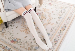 Detail von weißen Overknee-Socken mit blau-roten Streifen im klassischen College-Stil