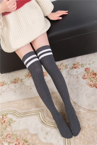 Vue macro de chaussettes hautes grises avec texture côtelée et doubles rayures blanches
