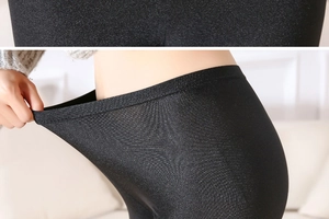 Detail shot of black high-gloss leggings showing exceptional elasticity and shiny texture