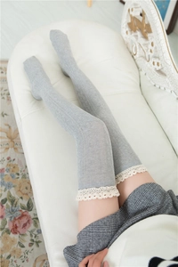 Close-up of light grey cotton thigh high socks with lace trim and vertical rib texture