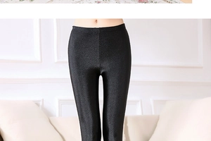 Detail of high-waist glossy black leggings showing the seamless elastic compression fabric