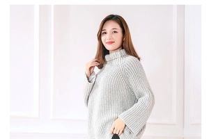 Close-up of light gray chunky knit turtleneck sweater with premium ribbed texture details