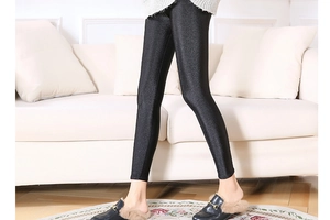 Detail of high-gloss black leggings with elastic stretch and sleek faux leather finish