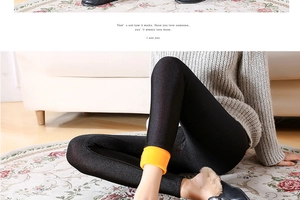 Close-up of women's black thermal leggings showing thick orange fleece lining detail