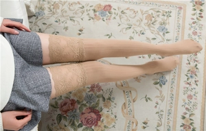 Detailaufnahme von breitem Spitzenbesatz und vertikaler Rippenstruktur an Overknee-Strümpfen