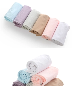 Macro view of six pastel-colored summer sun protection sleeves neatly rolled on white background