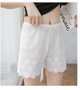 Detailed view of white cotton lace safety shorts featuring delicate hollow floral embroidery