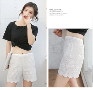 Detailed view of white cotton lace safety shorts with delicate floral embroidery and scalloped edge