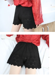 Detail of black cotton safety shorts with floral lace embroidery and scalloped edges