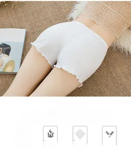 Detail of white high-waisted safety shorts with elastic ribbed fabric and ruffled trim