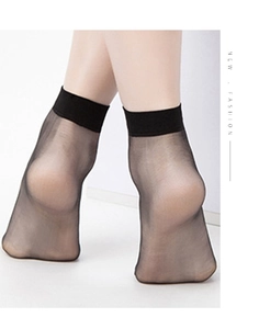 Macro detail of sheer black ankle socks with wide anti-slip cuffs on model feet