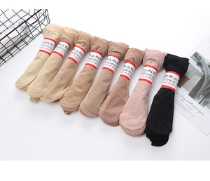 Detail of velvet ankle socks in skin tones and black with red brand labels in a basket