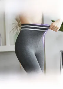 Close-up of high-elastic waist on grey compression leggings with contrast stripes
