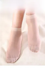 Detail of sheer nude ankle socks with reinforced toe on textured fabric background