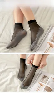 Detail of sheer black women's crew socks with jacquard patterned cotton reinforced sole