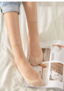 Detail of ultra-thin beige silk socks featuring elegant lace toes and seamless cuffs