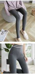 Detail of high waisted dark grey thermal leggings with white stripes and stirrup foot design