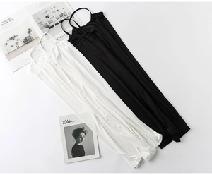 Detailed flat lay of black and white modal camisoles with slim straps on a white surface