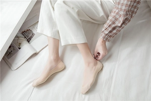Detailed view of nude invisible boat socks with non-slip silicone on female feet