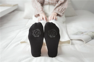 Detail of rose-shaped silicone non-slip grip on the sole of black invisible socks