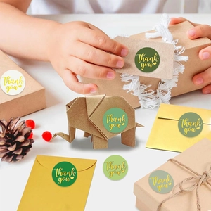 Green and white round Thank You labels used for decorating gift boxes and envelopes