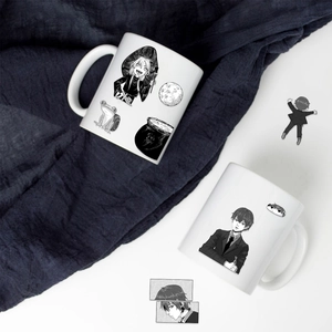 Top view of two white ceramic mugs with black and white anime manga style illustrations
