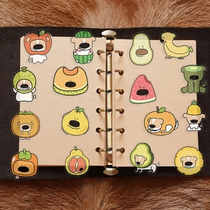 Close-up of cute fruit-themed dog stickers applied on a vintage journal page
