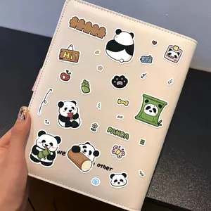 Close-up of cute cartoon panda DIY journal stickers on a beige leather notebook cover