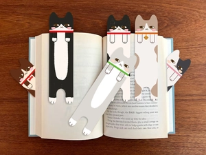 Detail van schattige kattenbladwijzers in een boek op een donkere houten achtergrond