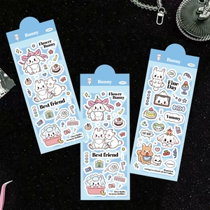 Close-up of cute cartoon bunny stickers for DIY journals on a sleek black background