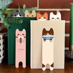 Schattige cartoon kattenbladwijzers in diverse kleuren in boeken op een tafel