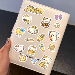 Detail of cute cheese cat and dog stickers applied on a cream leather notebook cover