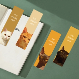 Detail of four creative cartoon cat bookmarks with You Pawsed Here text on paper