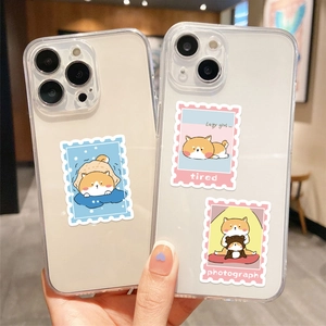 Gros plan de coques de téléphone transparentes avec des autocollants Shiba Inu mignons