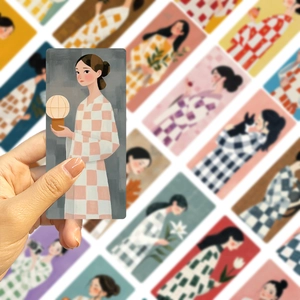 Detail of hand holding creative cartoon girl illustration bookmarks with paper texture