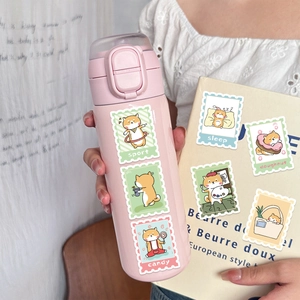 Détails d'autocollants timbres Shiba Inu sur un thermos rose et un carnet