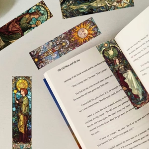Segnalibri artistici in vetro colorato dei tarocchi in un libro aperto sulla scrivania