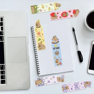 Detailed view of cute cartoon capybara bookmarks in a desk setting with a notebook