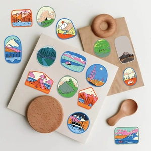 Pegatinas de camping al aire libre con diseños retro de montaña y carpa sobre fondo de madera