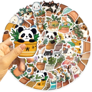 Mano che tiene un adesivo panda da un set di adesivi impermeabili per laptop