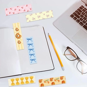 Close-up of 6 aesthetic Coquette bookmarks with bear and cherry patterns on office desk