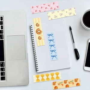 Flat lay of colorful Coquette bookmarks with cherry and bear patterns on white desk