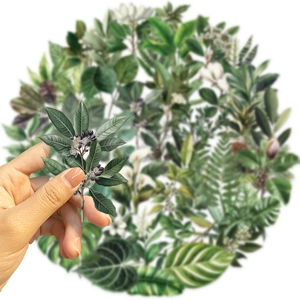 Close-up showing a hand holding a transparent waterproof PET green leaf sticker for journaling