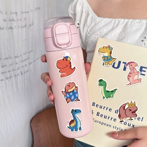 Nahaufnahme einer rosa Thermoskanne mit bunten Cartoon-Dinosaurier-Aufklebern