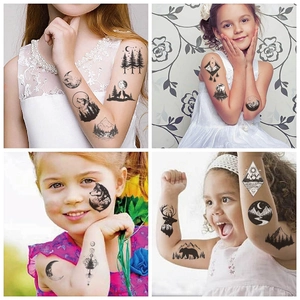 Detail of waterproof temporary tattoos featuring wolf, bear, and forest patterns on skin