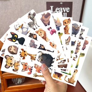 Main tenant une variété d'autocollants d'animaux colorés pour fêtes et cadeaux enfants