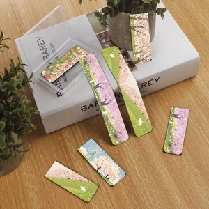 Detail of 7 sunset whisper magnetic bookmarks with floral designs and storage case