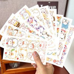 Primo piano di mano con adesivi per tatuaggi colorati di animali dello zodiaco