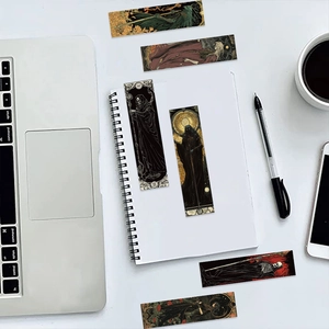 Close-up of vintage gothic wizard bookmarks with dark art illustrations on a white desk